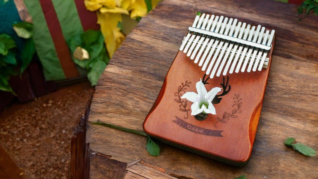 A Goldesi kalimba placed on a rustic wooden surface, showcasing its elegant design and craftsmanship.