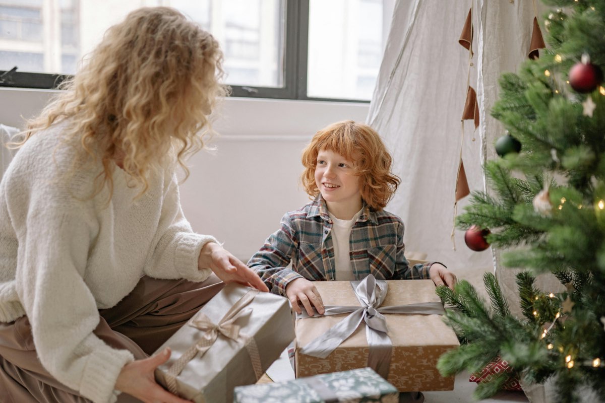 A child receiving a beautifully wrapped gift during the holidays, showcasing the perfect moment to give a Goldesi Kalimba.