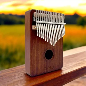 Wooden kalimba with 17 keys from Goldesi, displayed on a wooden surface during sunset.