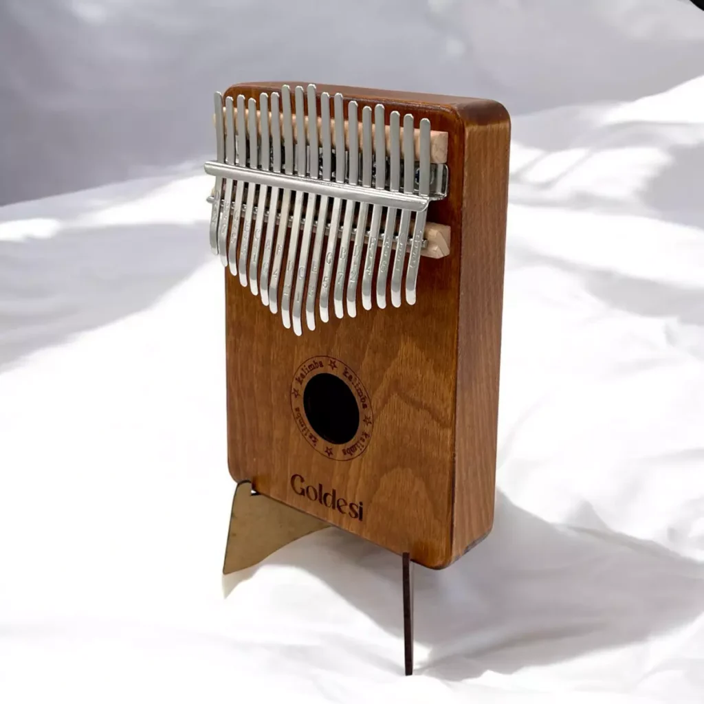 Goldesi Kalimba standing upright on a wooden stand under soft daylight
