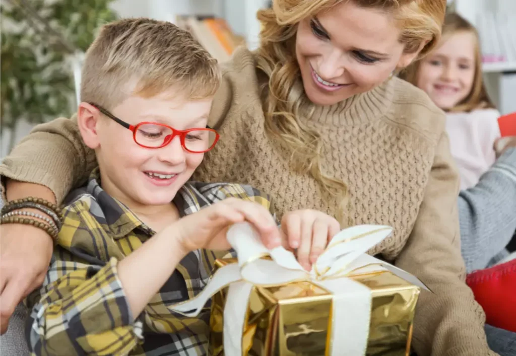 Mother giving a xylophone gift to her child, with the child happily opening the package